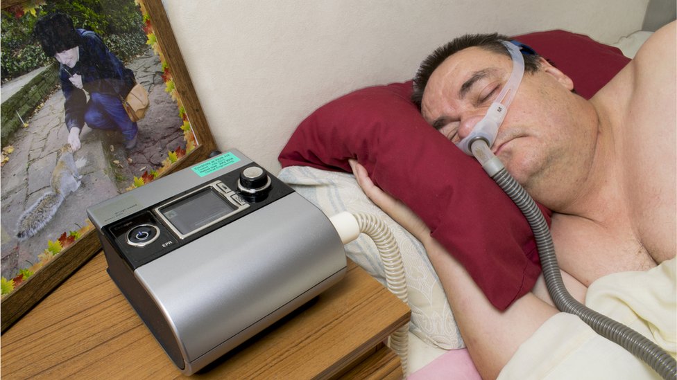 Hombre usando máquina para respirar.